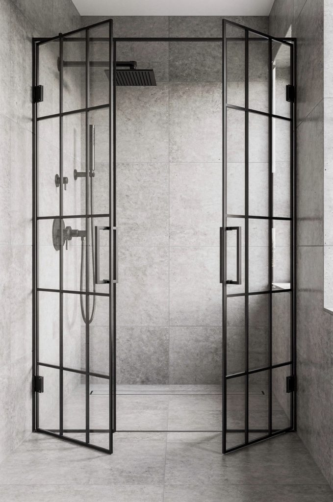 Industrial bathroom with grid-style glass shower doors, black metal frame, large format tiles, and walk-in shower.